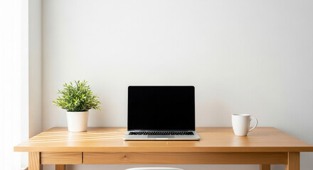 Fototapeta premium Modern minimalist workspace featuring a laptop, plant, and coffee mug on a clean wooden desk