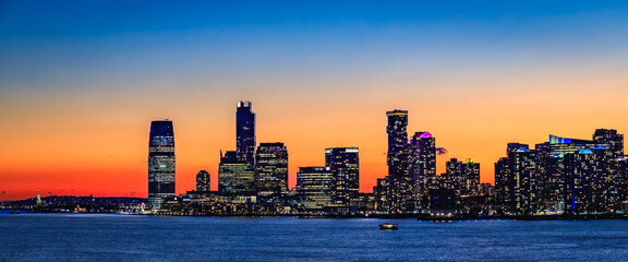 Jersey City skyline silhouette from New York, dramatic sunset over Hudson River