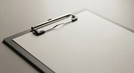 Professional clipboard with blank paper and metal clip for notes, plans, or reports in a clean office setting.