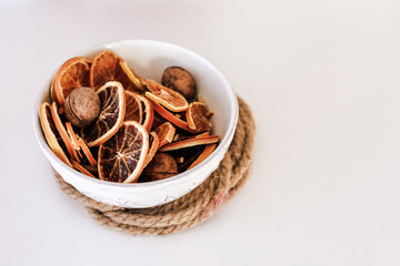Dried citrus and nuts arranged in a decorative bowl on a rustic surface