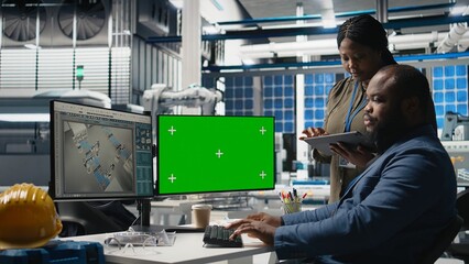 Professionals brainstorming solutions with mockup screen in solar facility, advancing industrial goals through collaboration and corporate responsibility. Team of engineers share insight. Camera A.