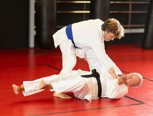 Naklejka premium Karate with two male athletes practicing, training and sparring in fight class