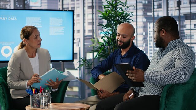 Corporate leadership team in a business meeting use data driven analysis and strategic thinking to identify insights and guide executive decisions across a global company. Camera B.