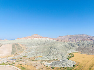 Nallıhan in Ankara, Turkey reveals colorful striped hills and natural erosion patterns. The aerial view displays farmland, arid terrain, and geological textures in a vivid natural landscape.