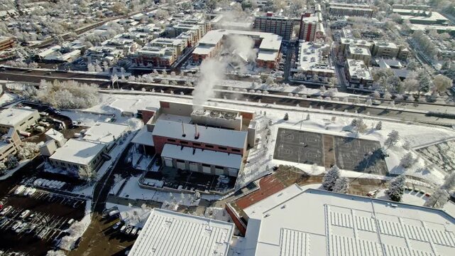 Factory with smoke coming out in snow covered landscape 4K