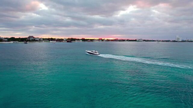 Yatch cruising in front of sunset with turquoise water 4K