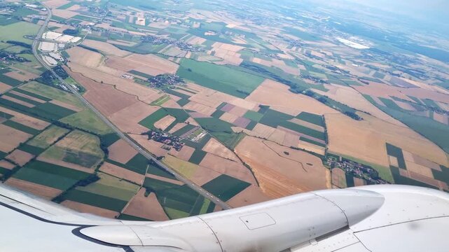 Aerial View of Scenic Patchwork Farmland and Fields from Airplane Window for Travel and Landscape Design