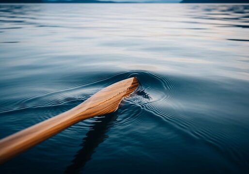 Wooden Oar Immersed in Calm Blue Water Creating Concentric Ripples on Serene Lake Surface. - Powered by Adobe