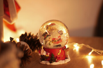 Glass snow globe with reindeer on a red base, glowing festive background