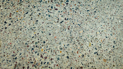 a close-up of smooth concrete, with exposed aggregate. multi-color abstract exterior background with copy space