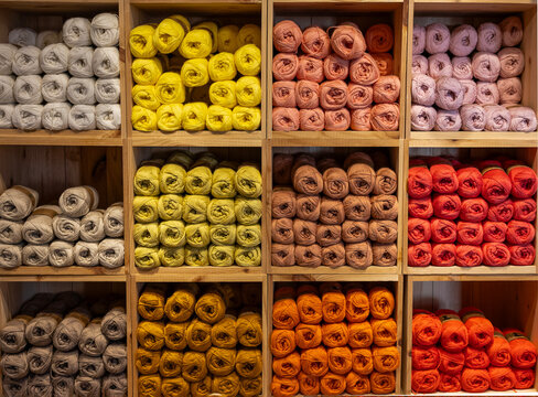 Estantes llenos de ovillos de fibras  textiles, ,  para tejer punto, coser o hacer ganchillo. 