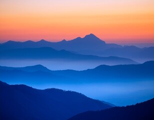 softly glowing peaks of layered blue mountains against a vibrant gradient sky with hues of pink and orange during sunrise on a misty morning orange blue layering