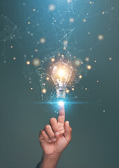 Futuristic thinking for business and science concepts. Close-up of hand touching glowing light bulb with digital network connections. Symbolizing innovation. Creative ideas. Technology solutions.