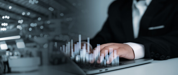 Business executive typing on laptop with transparent data graph overlay, representing data analysis, management, and logistics systems in modern organizations.