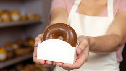 White doughnut packaging in the hand of a pastry chef