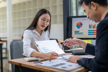 Business people analyzing charts on paper and computer screen