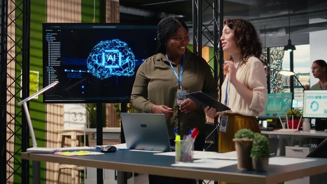 Diverse manager and assistant uses robotics data and neural networks visualization, work in a corporate environment to support deep learning initiatives for productivity and workflows. Camera A.