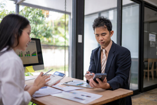 Business people analyzing charts and data on computer and smartphone