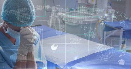 Standing surgeon in blue scrubs at operating table in surgical suite, with data overlay, copy space