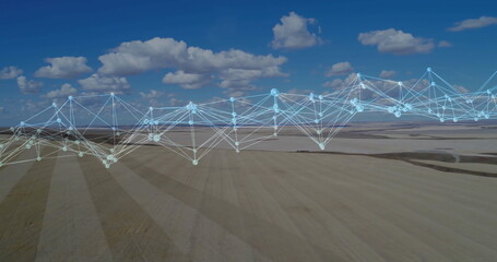 Spanning digital network overlay connecting nodes across farmland fields below scattered clouds © vectorfusionart