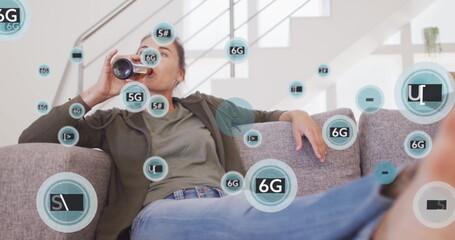 Reclining woman drinking from dark can on grey sofa in living room, with 5G 6G icons