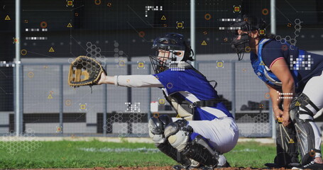 Squatting female catcher extending glove at ballpark, with teammate watching and digital overlays
