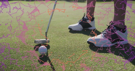 Golfer aligning putter head with golf ball on green, ankle socks, golf shoes, with digital overlay