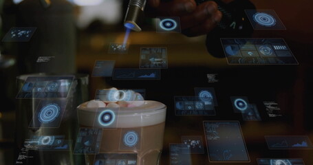 Barista wearing shirt torching frothy coffee mug with marshmallows at cafe with holographic panels