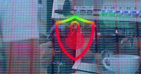 Standing coworker trio discussing data security on laptop in office, red shield icon, code overlay