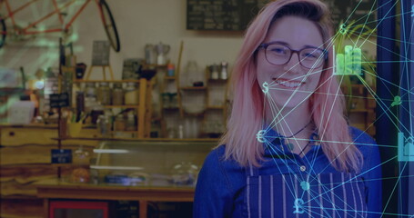 Smiling barista serving behind café counter in apron with display case, digital overlay, copy space