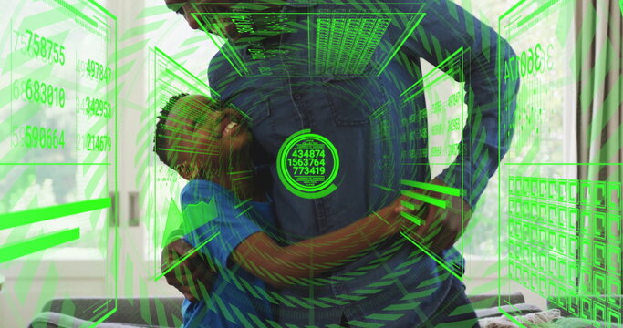 Father in blue shirt hugging son in teal on sofa at home, holographic panels, keyboard floating