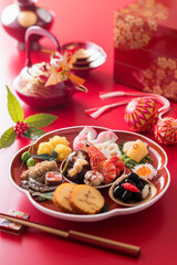 【おせち料理】新年をお祝いするお正月。食材ひとつひとつに健康や繁栄の願いが込められたおせち料理。車海老・くわい・椎茸・蓮根・京人参・鞠麩が入った海老と野菜のうま煮。数の子。昆布巻き。伊達巻。紅白蒲鉾。菊花かぶ。牛肉の紅白巻き。田作り。黒豆。いくら。栗きんとん。たたきごぼう。