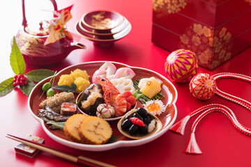 【おせち料理】新年をお祝いするお正月。食材ひとつひとつに健康や繁栄の願いが込められたおせち料理。車海老・くわい・椎茸・蓮根・京人参・鞠麩が入った海老と野菜のうま煮。数の子。昆布巻き。伊達巻。紅白蒲鉾。菊花かぶ。牛肉の紅白巻き。田作り。黒豆。いくら。栗きんとん。たたきごぼう。