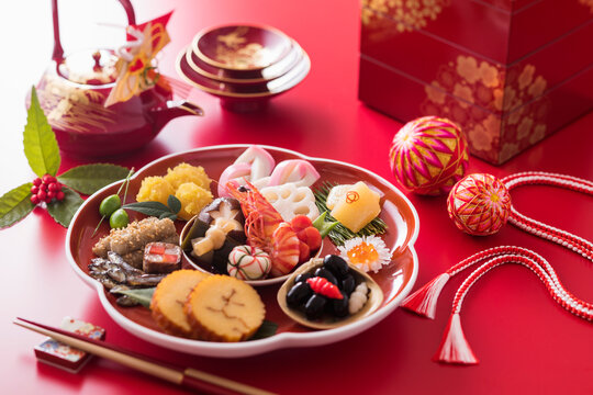 【おせち料理】新年をお祝いするお正月。食材ひとつひとつに健康や繁栄の願いが込められたおせち料理。車海老・くわい・椎茸・蓮根・京人参・鞠麩が入った海老と野菜のうま煮。数の子。昆布巻き。伊達巻。紅白蒲鉾。菊花かぶ。牛肉の紅白巻き。田作り。黒豆。いくら。栗きんとん。たたきごぼう。