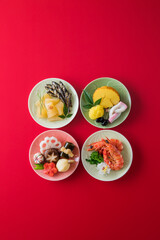 【おせち料理】新年をお祝いするお正月。食材ひとつひとつに健康や繁栄の願いが込められたおせち料理。栗きんとん・伊達巻・黒豆・紅白蒲鉾。くわい・椎茸・蓮根・京人参・昆布巻き・鞠麩が入った野菜のうま煮。数の子・田作り。車海老・菜の花・菊花かぶ。たたきごぼう・牛肉の紅白巻き。