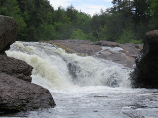 White Water of Sandstone Falls Cascading over Brown Rocks Surrounded by Green Woods Forest under Blue Sky and White Clouds