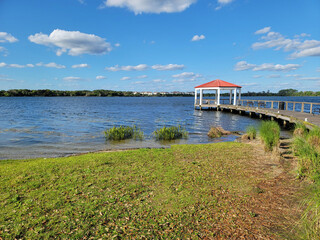 Gazebo - Lake Baldwin Park in Orlando, Winter Park, Florida, USA. Lake view landscape with red gazebo. Ecological Park for visitors on a travel vacation in Orlando, Florida, USA.