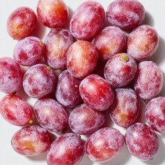 Obraz premium In a flat lay arrangement viewed from the top, red grapes with green leaves and sliced halves are positioned on a transparent background, complemented by a background with a textured pattern of