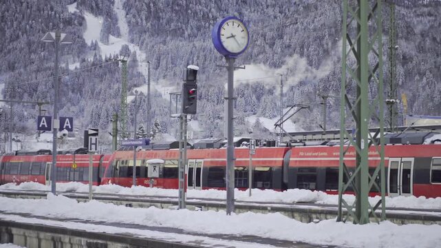 Eisenbahnreisen durch die verschneiten Bayerischen Alpen. Der Bahnhof Garmisch-Partenkirchen ist ein wichtiger Verkehrsknoten fur Regional und Fernzuege, ideal fur Wintertourismus in den Bergen. 