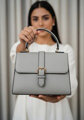 Woman Presenting a Light Gray Leather Top- Handle Handbag with Buckle purse