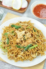 Indonesian style stir fry noodles with, egg,  green mustard, chilli and crackers.