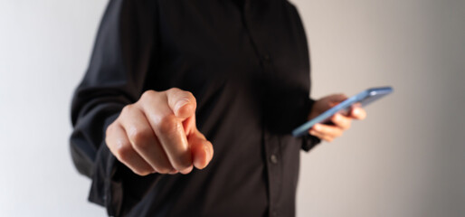 Business person pointing forward holding a cell phone