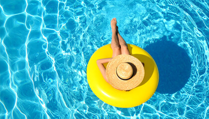 Woman Relaxing on a Yellow Inflatable Float in a Shimmering Blue Swimming Pool on a Sunny Day