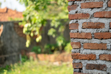 Half-collapsed brick wall with rough unfinished cement
