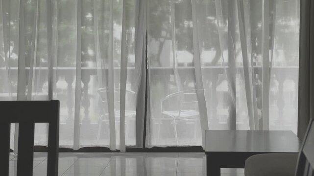 Gentle wind blowing the curtain in the interior of a cozy home. Soft light interior. Modern living concept. Residential living room.