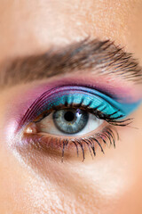 Obraz premium Close-Up of a Woman's Eye with Bold Blue and Pink Eyeshadow, Showcasing Dramatic Makeup and Intense Color for a Striking Beauty Statement