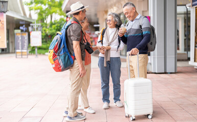 Senior asian tourism travel group reading guidebook together with smiles, enjoy retirement, friendly active aging tourism, senior health and wellness, retirement life insurance and vacation planning