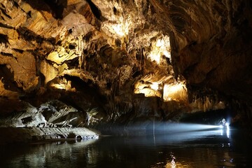 The boat light streams into Penn's Cave, illuminating the cave's intricate rock formations.