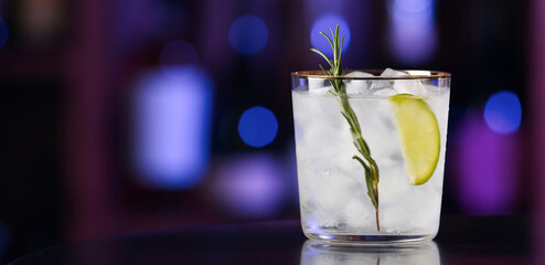 Glass of cold gin tonic on table in bar