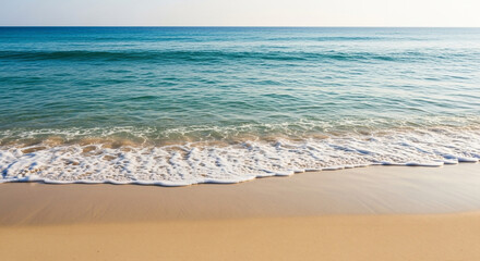 Gentle Waves Crashing onto Sandy Beach Under Clear Blue Sky